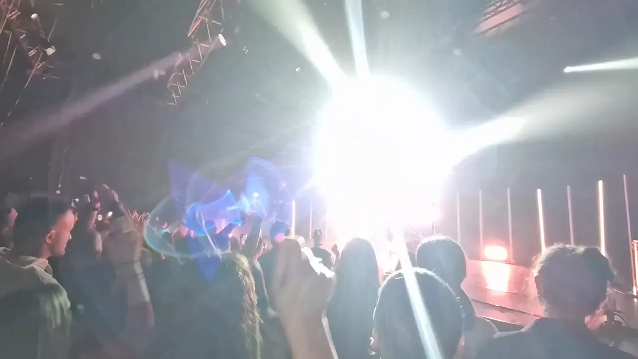 A performer singing on a lit stage in front of an audience